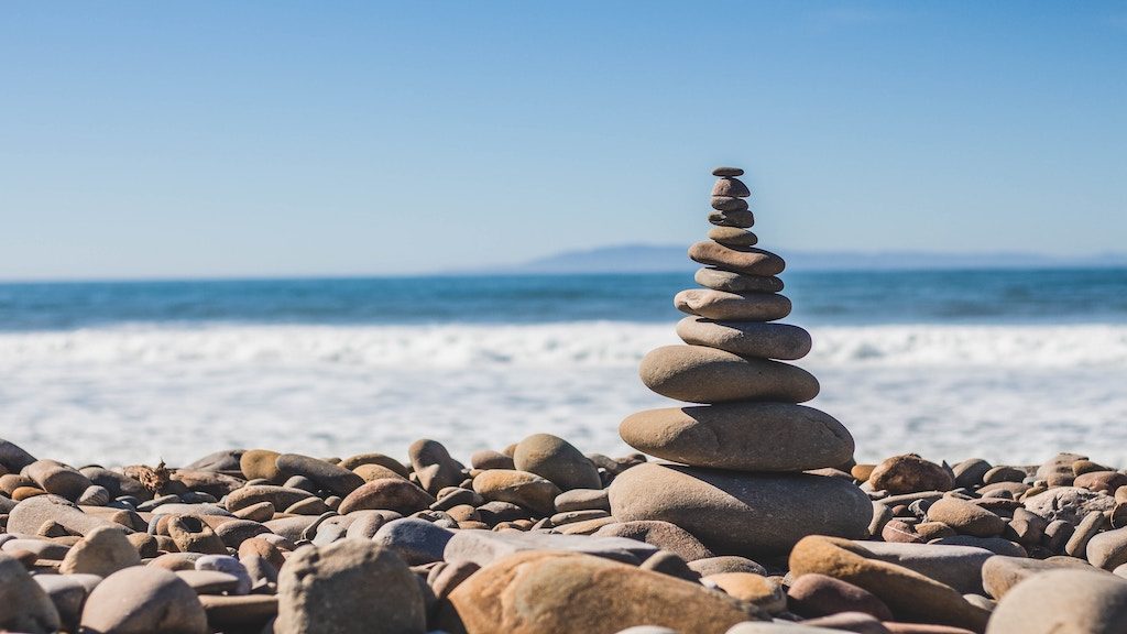 Six Building Blocks for Creating a Life of Balance and Wellness; image of rocks stacked near ocean