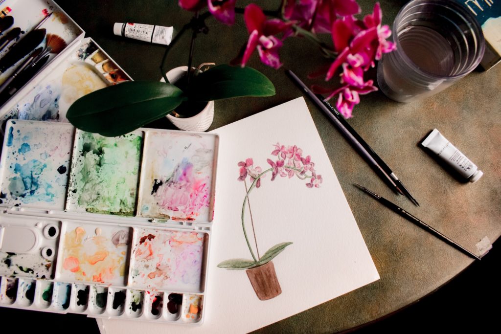 Eight Ways to Ease Anxiety and Age Well; image of an orchid, water color palette and watercolor painting
